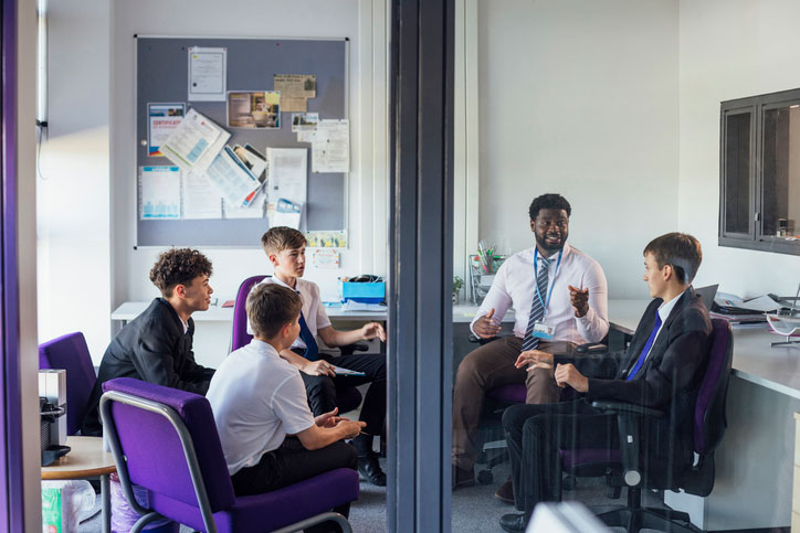 group of teen boys meeting with counselor